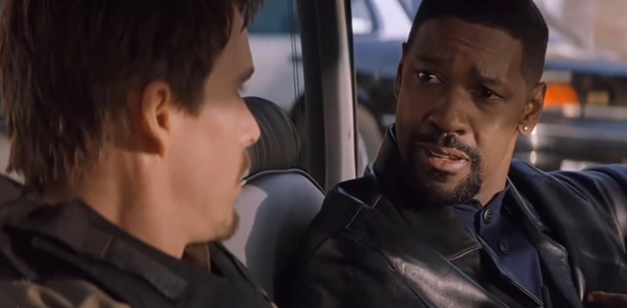 Two men sitting inside a car talking.
